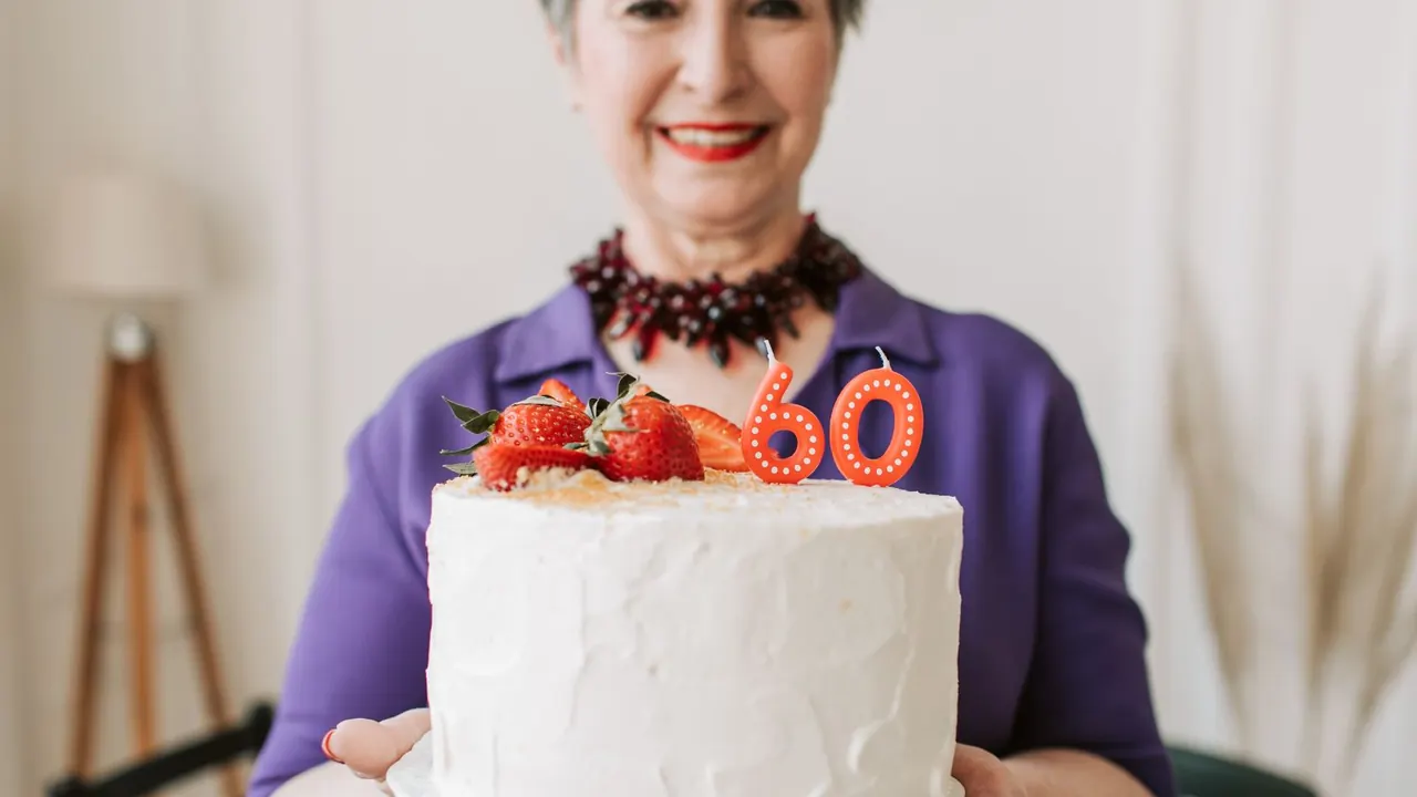 smiling woman holding a 60th birthday cake, image for funny 60th birthday cake sayings