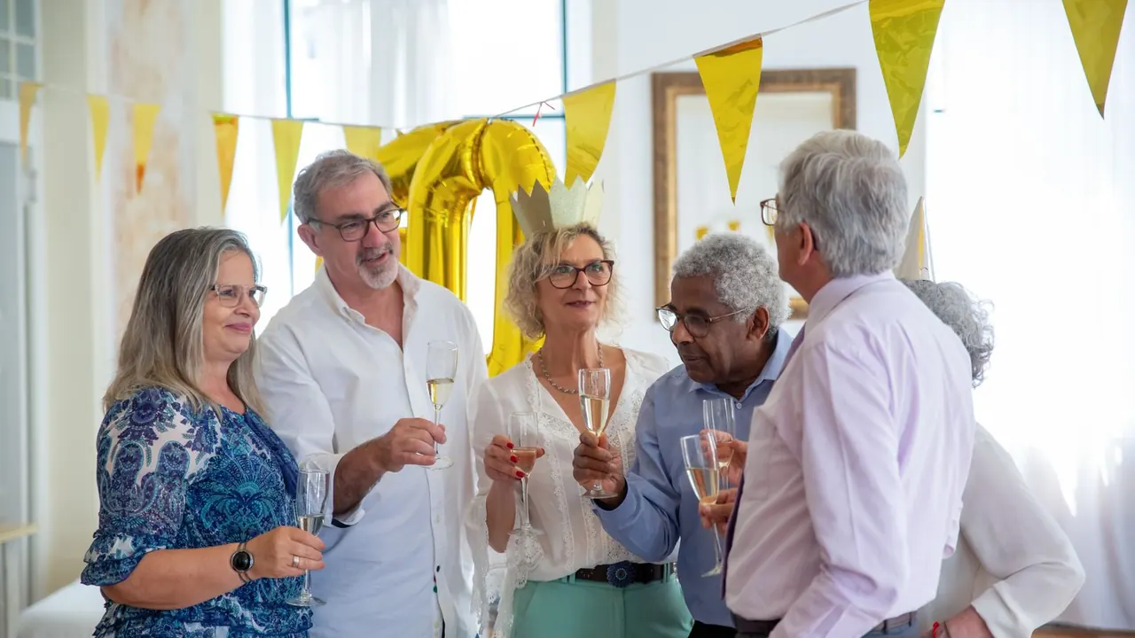 older adults in party hats laughing at a birthday party, image for 60th birthday jokes