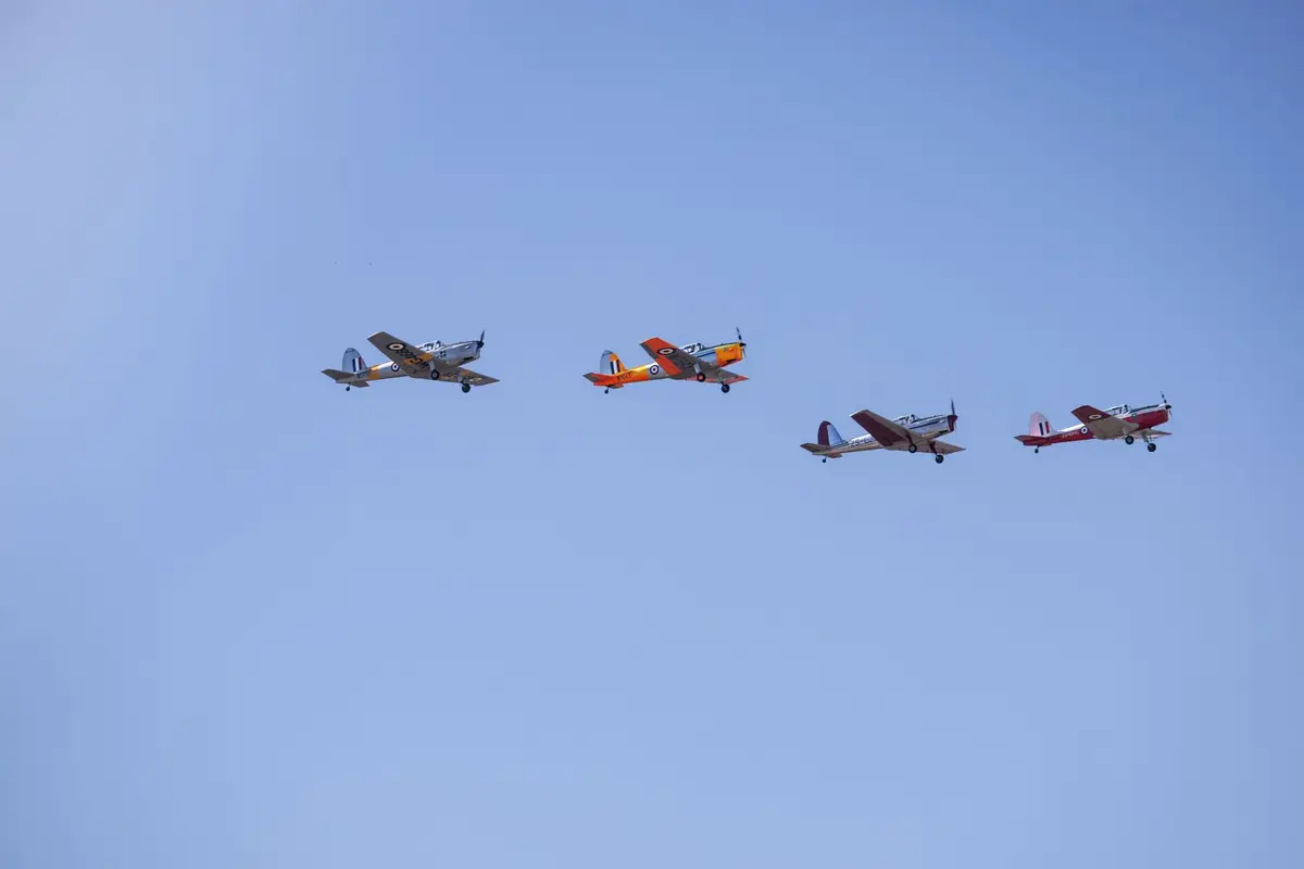 formation of vintage aircraft against a blue sky, student pilot and classroom jokes about flying