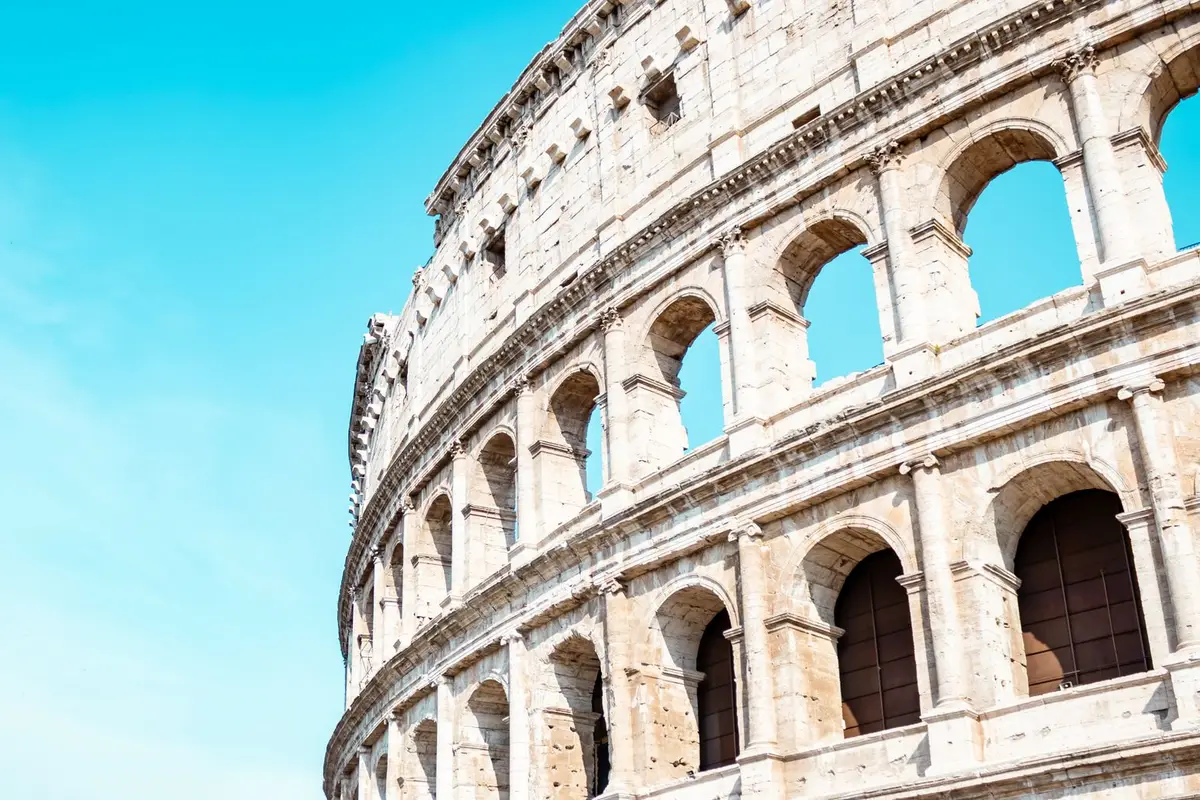 the Colosseum in Rome against a blue sky, Roman jokes about Caesar and gladiators