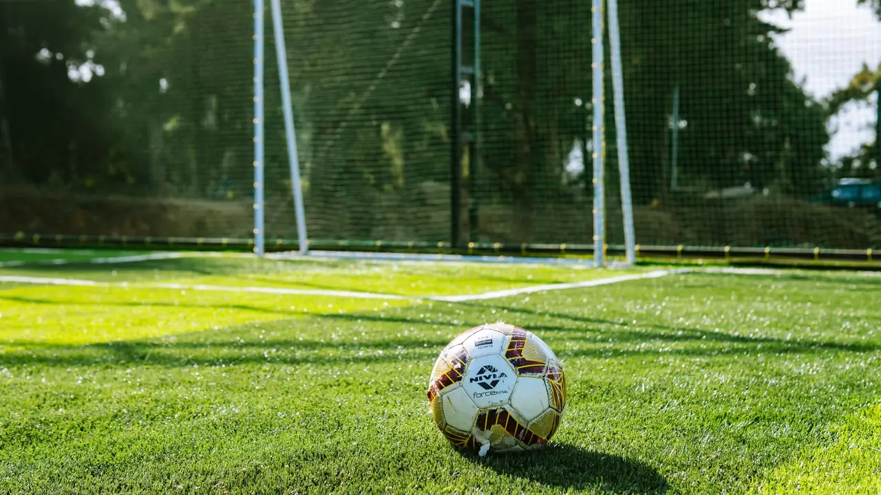 a football next to a goal net on a pitch, image for arsenal invincibles jokes