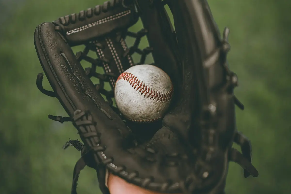baseball resting in a black leather glove, image for baseball glove and catch puns