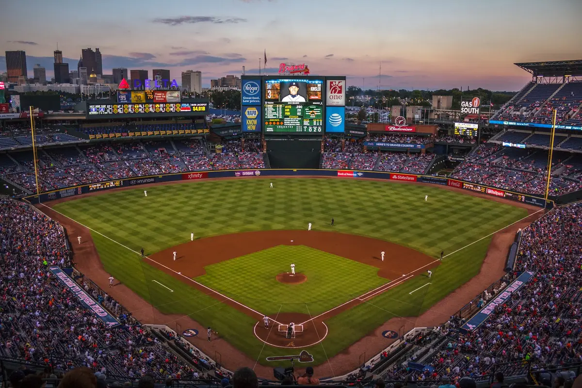 fans filling a baseball stadium at dusk, image for good heckling lines for baseball and funny baseball heckles
