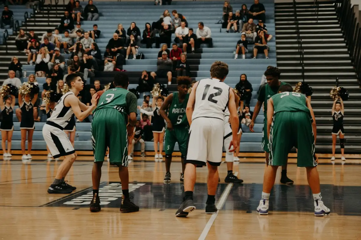 players lined up around the free throw line in a school gym, scene for free throw basketball puns
