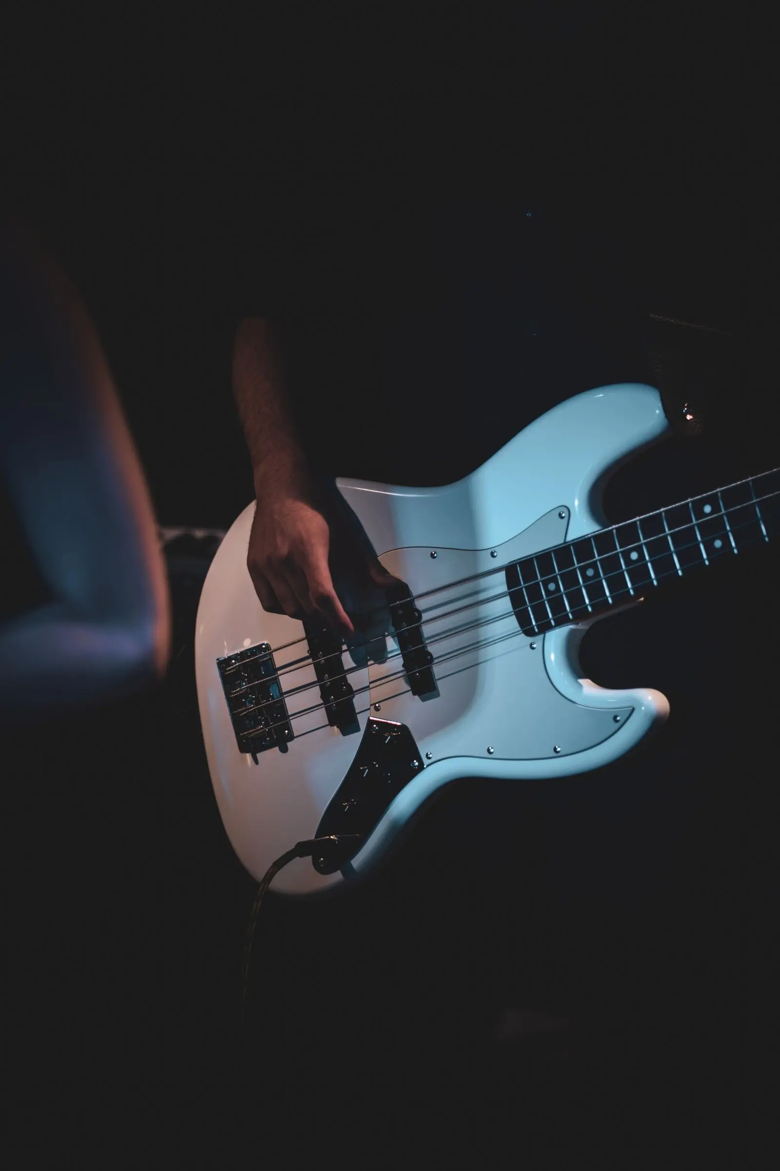 electric bass guitar performance under stage lights, image for bass guitar puns for bandmates