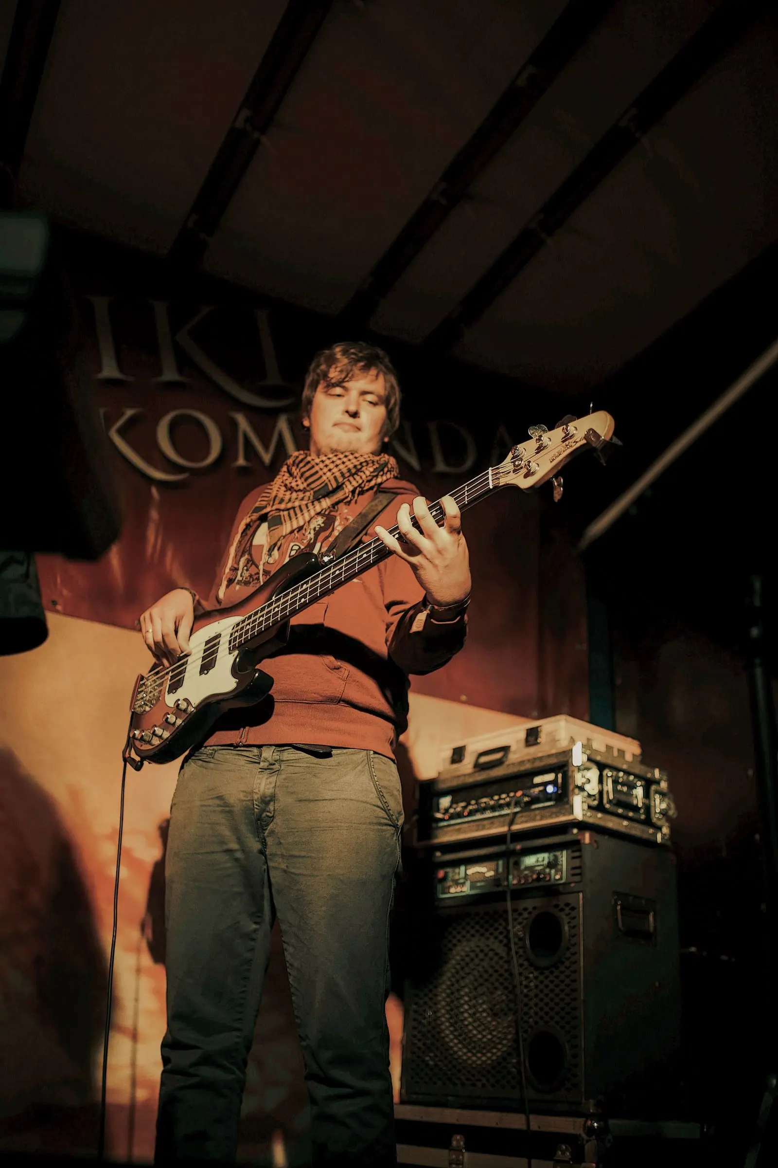 man playing a bass guitar on stage during a live concert, image for funny bass guitar puns