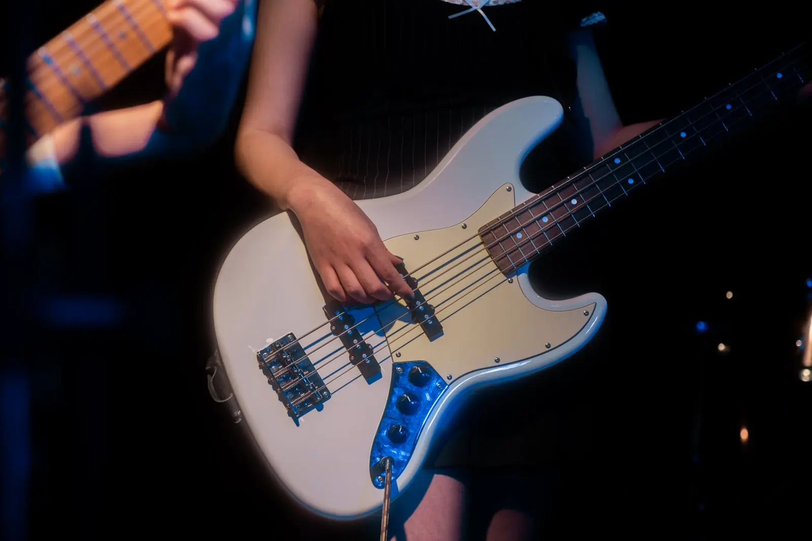 close-up of bass guitar performance at a rock concert, image for slap bass puns
