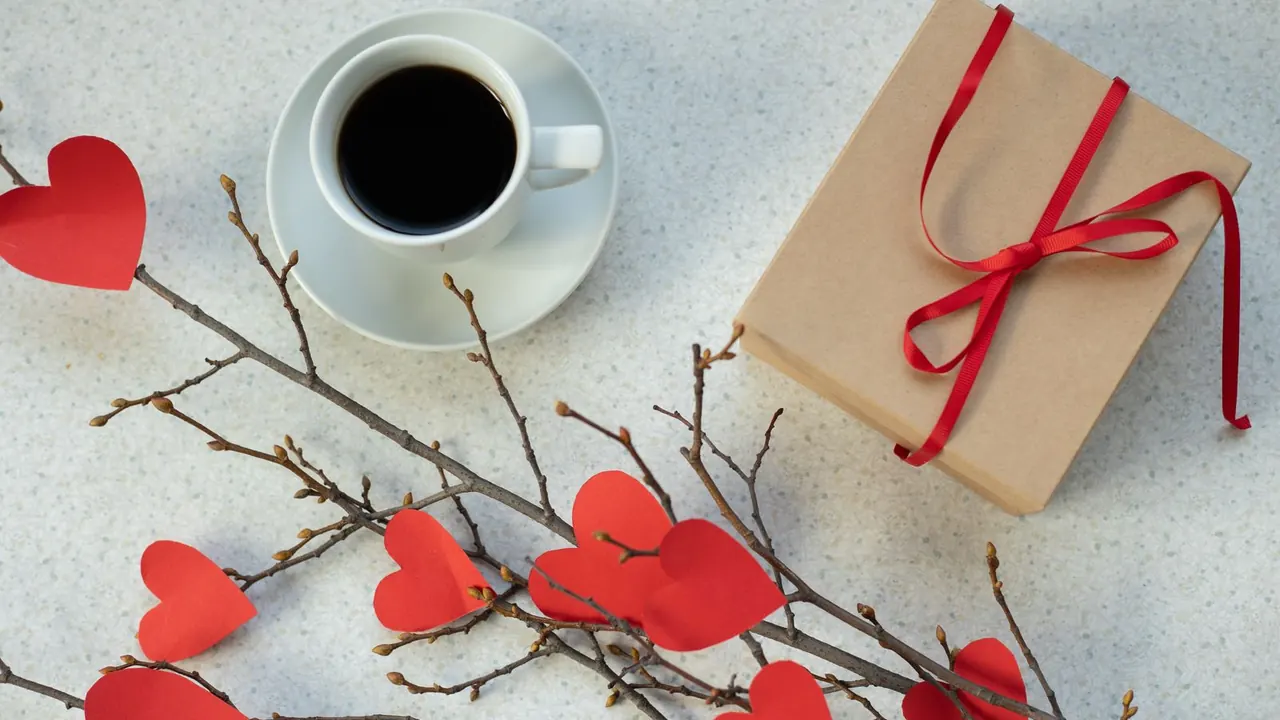 gift box with a red ribbon next to a cup of coffee, image for funny belated birthday quotes