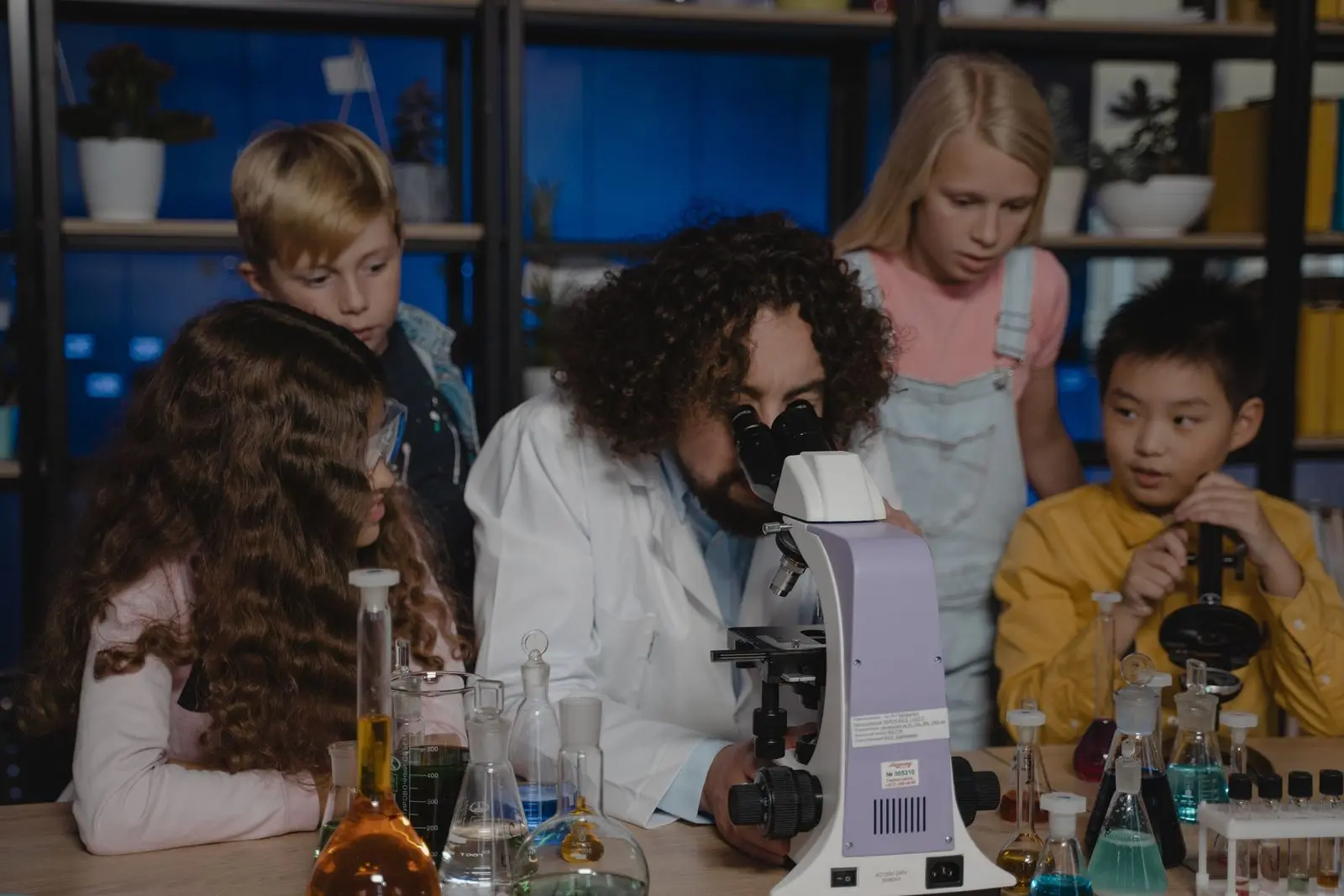 teacher doing a science experiment with students watching, image for biology jokes for teachers bell-ringers