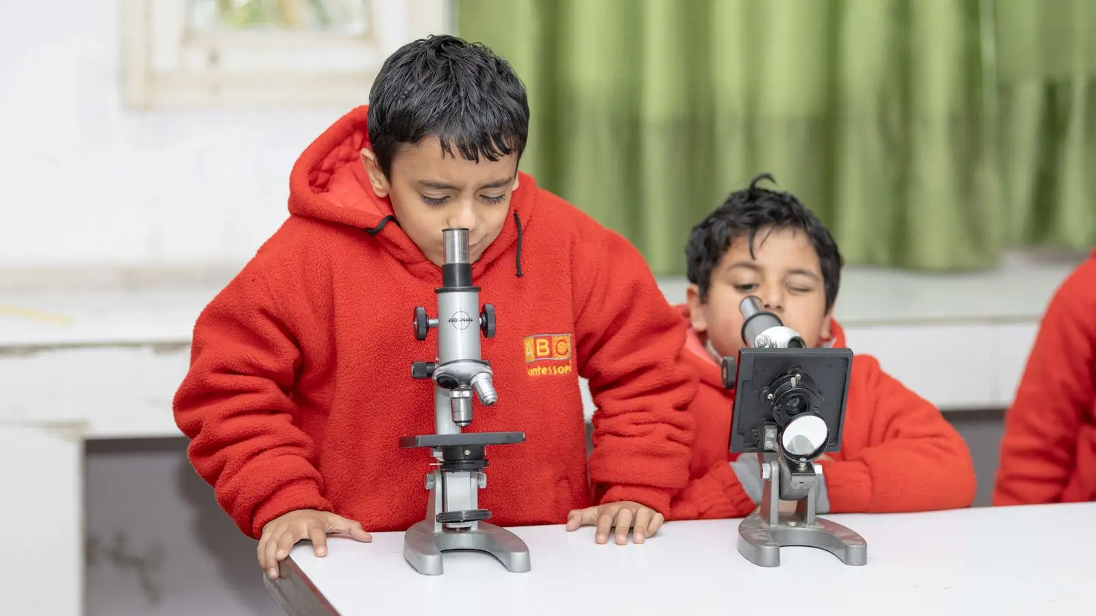 children exploring with microscopes in a classroom, image for biology jokes for students