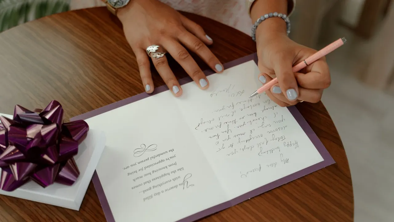 hand writing a message inside a greeting card, image for birthday card jokes
