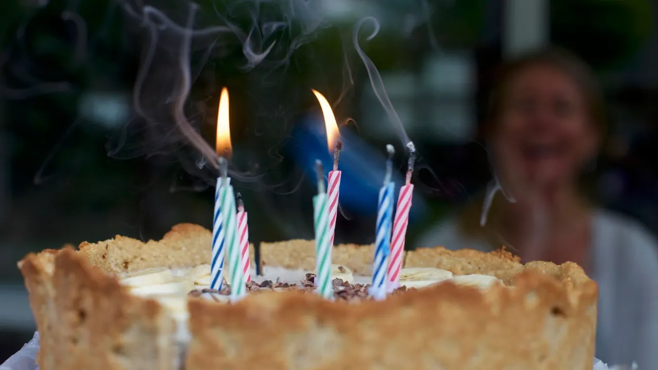 birthday cake with lit candles for a dad turning 50, image for 50th birthday dad jokes