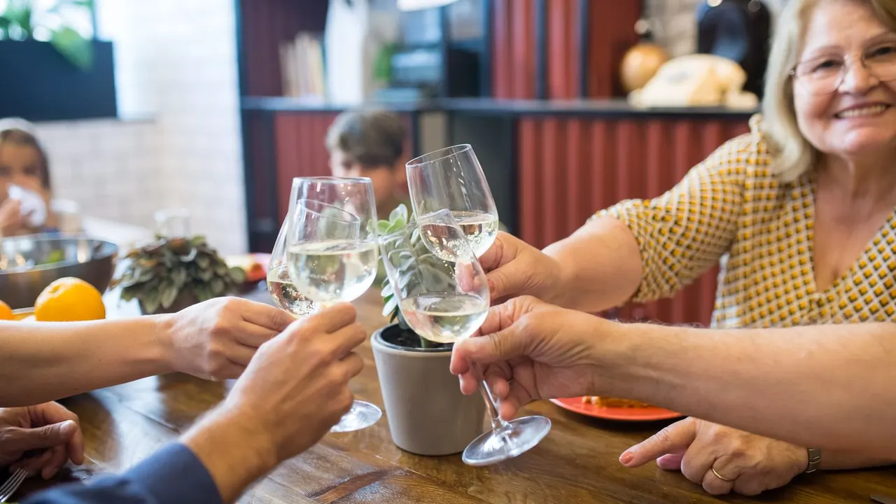 family and friends raising glasses at a birthday dinner for dad, image for dad joke birthday wishes