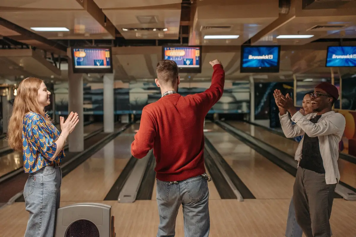 group of friends celebrating at a bowling alley, funny bowling jokes for league night