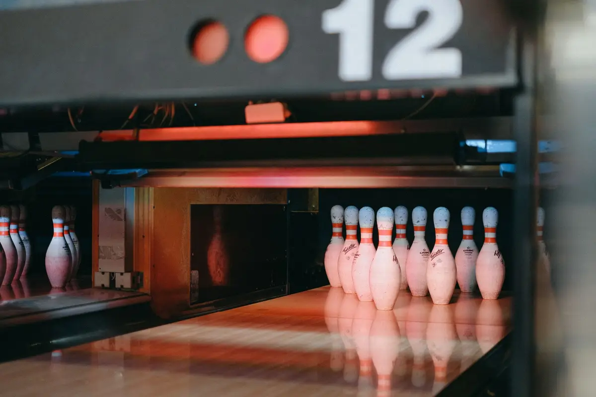 ten bowling pins lit up at the end of lane 12, bowling strike and spare jokes