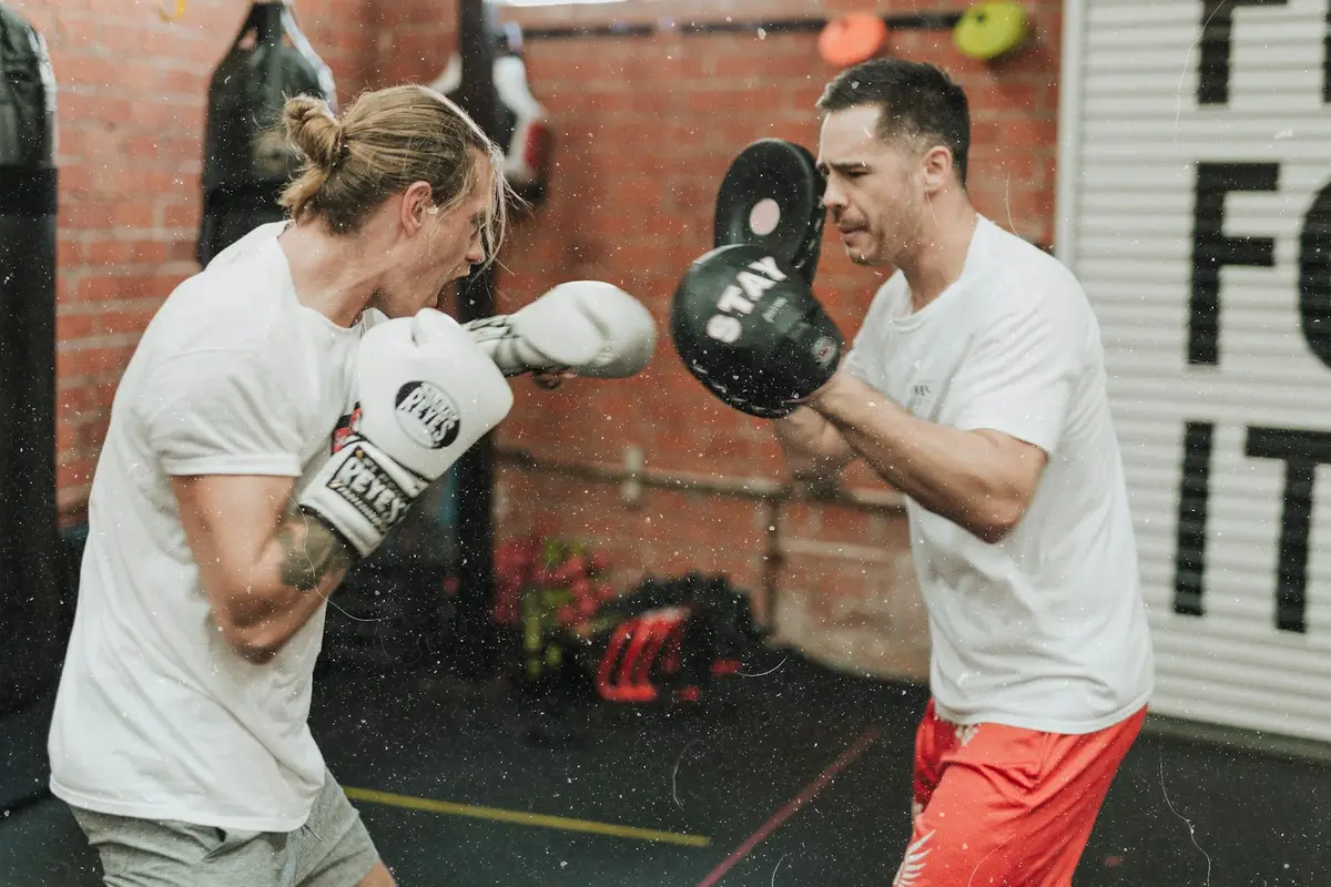 two boxers sparring inside a gym, scene for boxing puns one liners