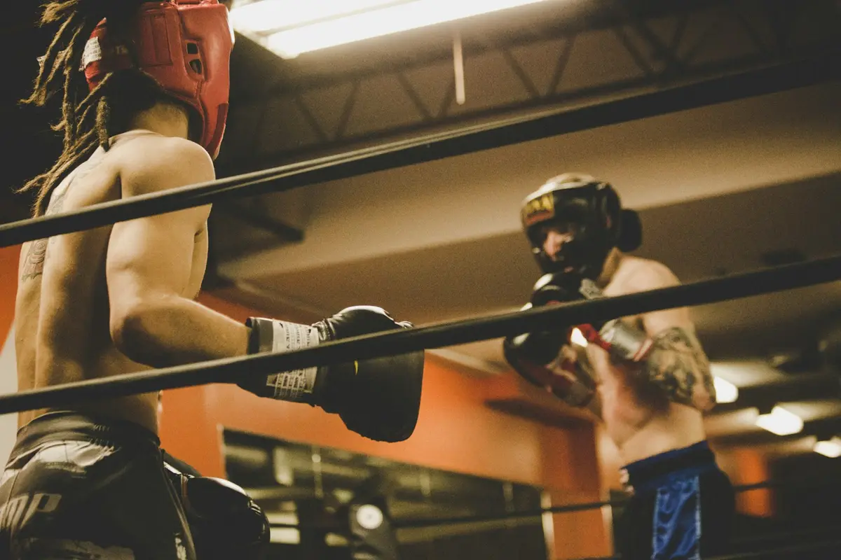 two fighters in training gloves inside a boxing ring, backdrop for boxing puns captions