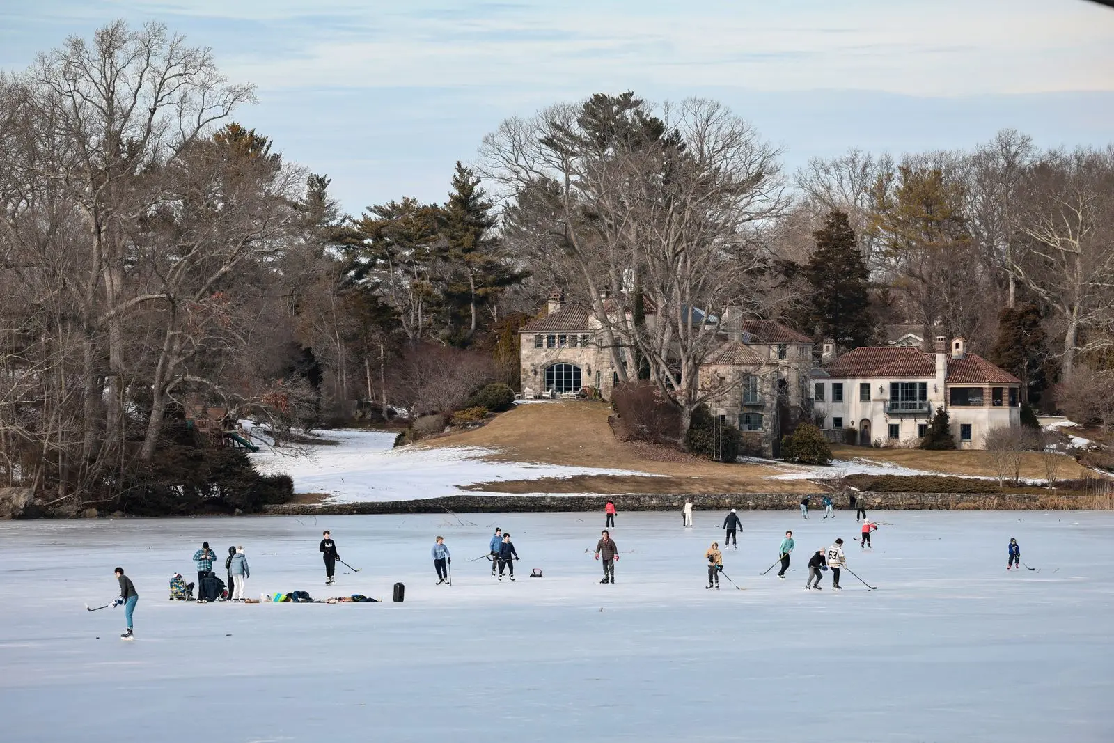 people playing ice hockey on a winter pond, image for clever christmas hockey puns for signs