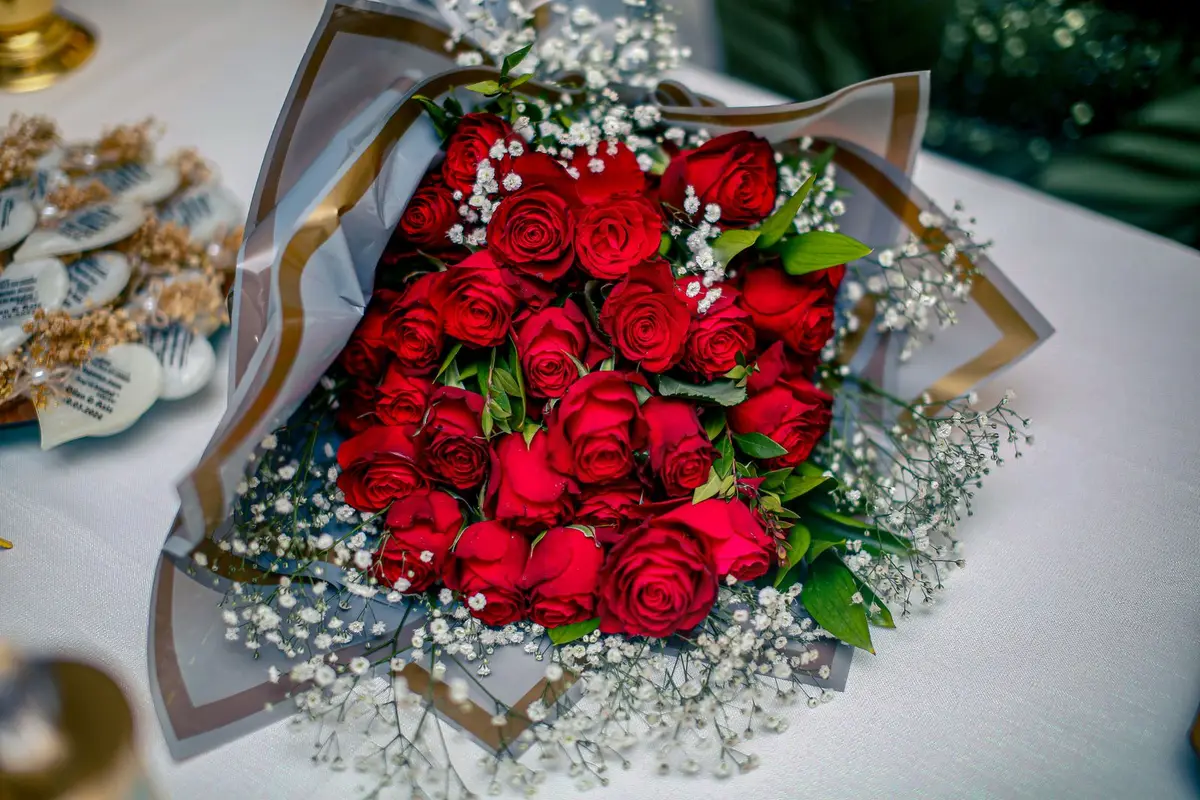 red rose bouquet with baby's breath on a white table, roses are red violets are blue jokes