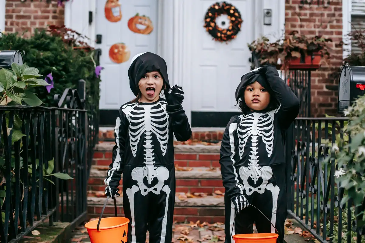 kids in skeleton costumes trick-or-treating with pumpkin buckets, dark humor jokes for kids