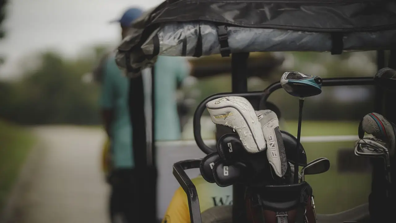 a golf bag full of clubs strapped to a cart, image for first tee golf jokes for men