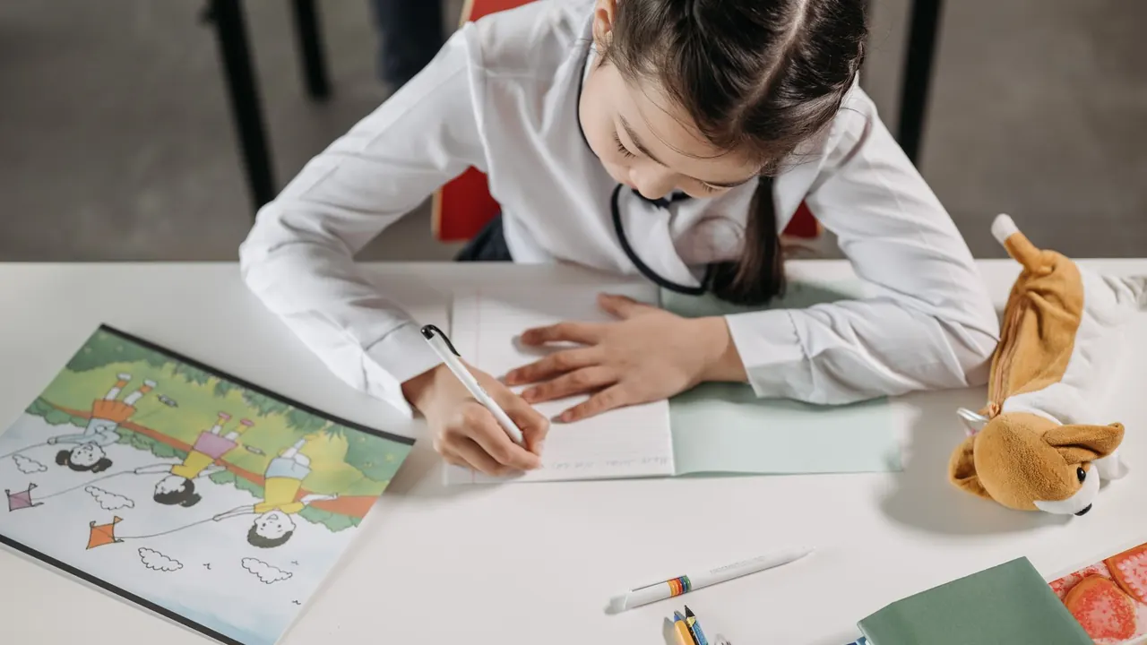 a student writing in a notebook with crumpled paper on the desk, image for verb jokes for students