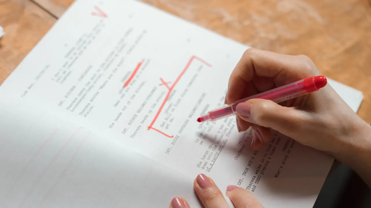 a hand correcting printed text with a red pen, image for comma jokes