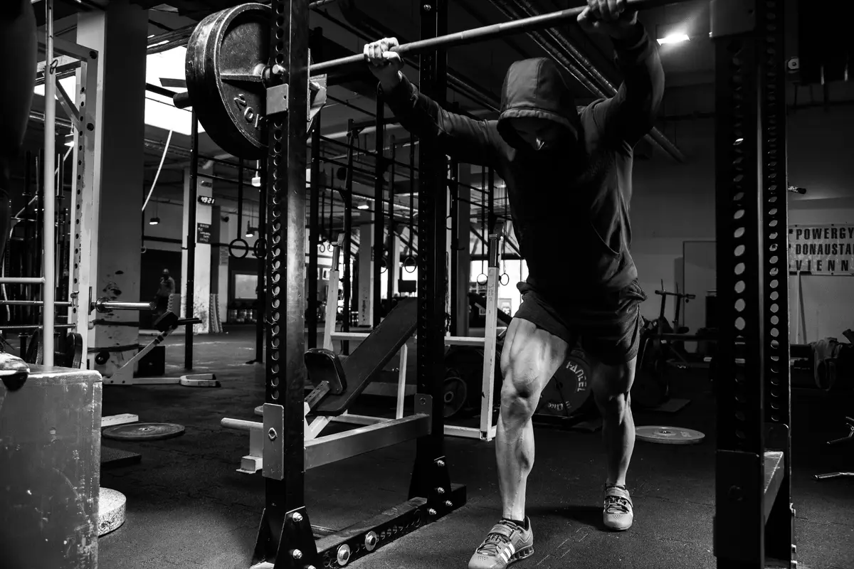 man doing a pull-up on a bar in a gym, scene for weightlifting puns and strength training puns