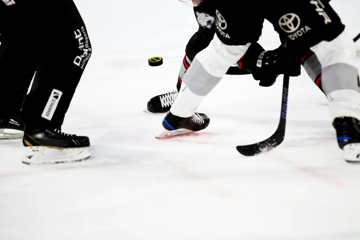 two hockey players battling for the puck on an ice rink, scene for hockey puns one liners