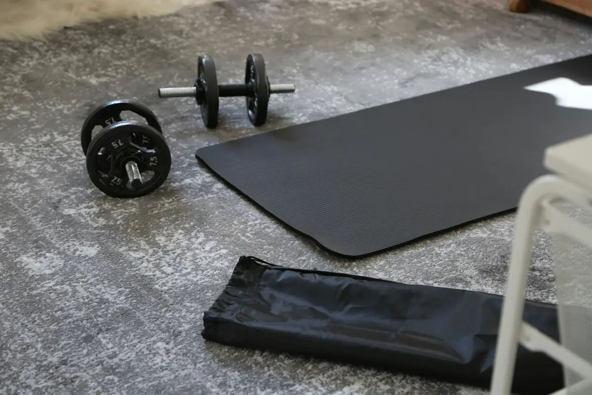 pair of dumbbells resting on a workout mat at home, scene for home workout puns and exercise puns