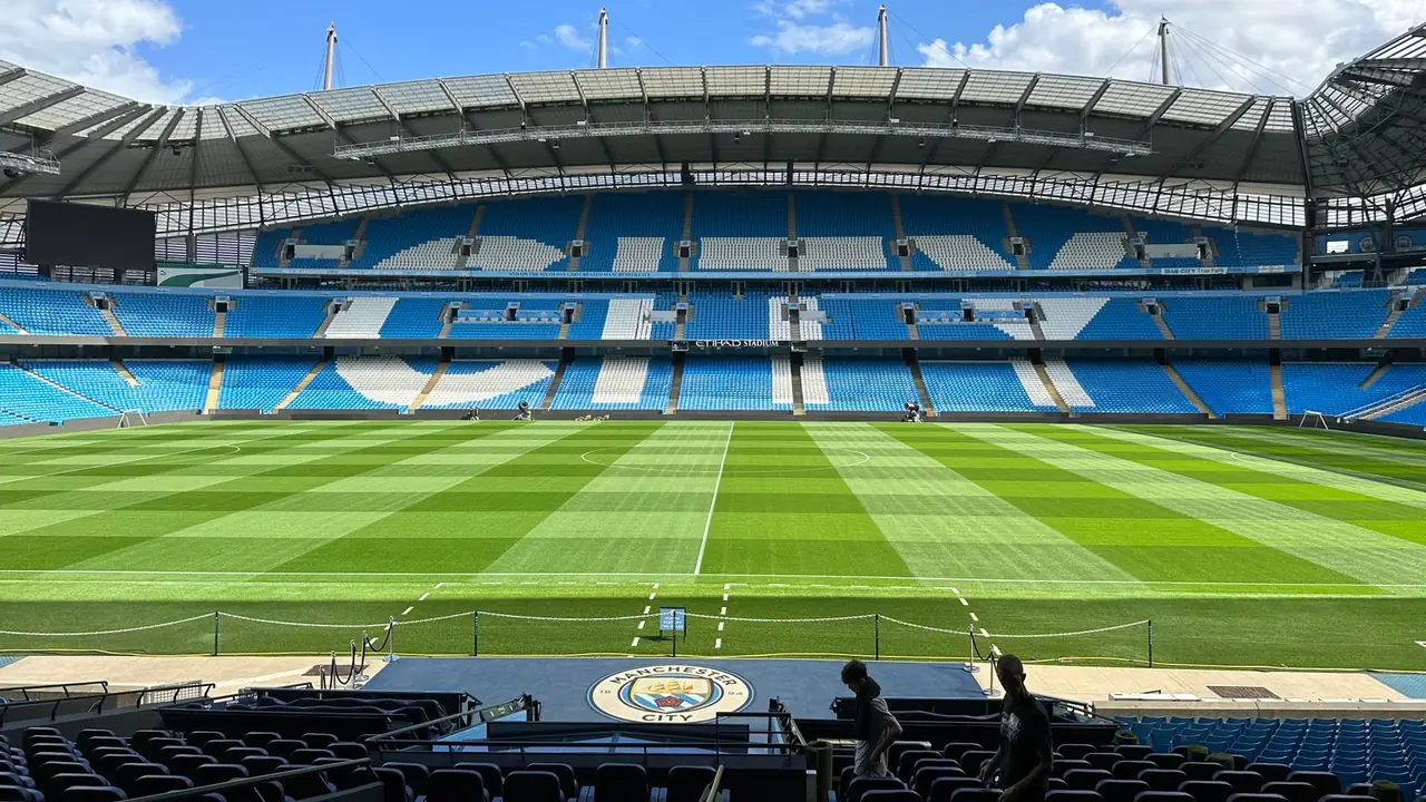 a football pitch with stands full of supporters, image for man city chants and Poznan jokes