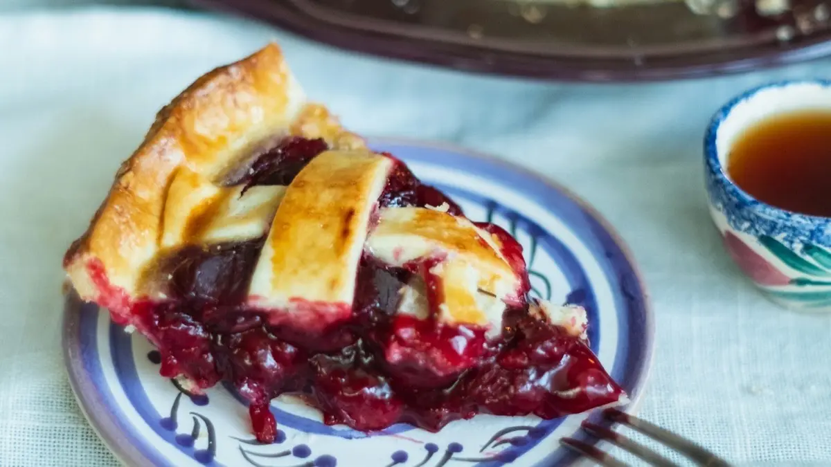 slice of lattice cherry pie on a plate, image for pi puns and Pi Day jokes