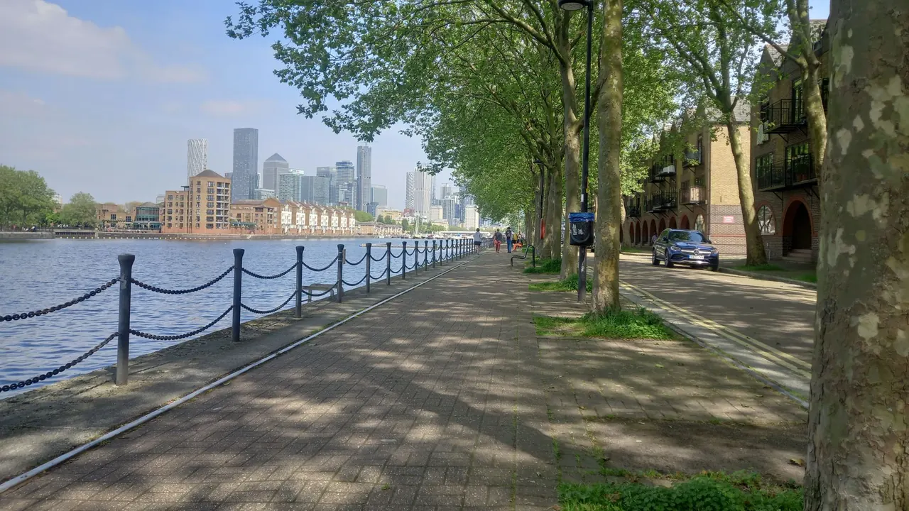 a riverside path along the thames with docklands towers in the distance, image for millwall dockers history jokes