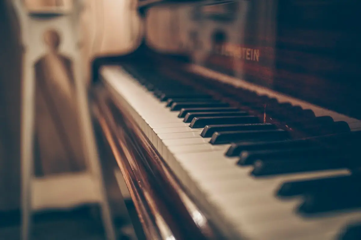 close up of upright piano keys in warm light, image for piano puns and keyboard jokes