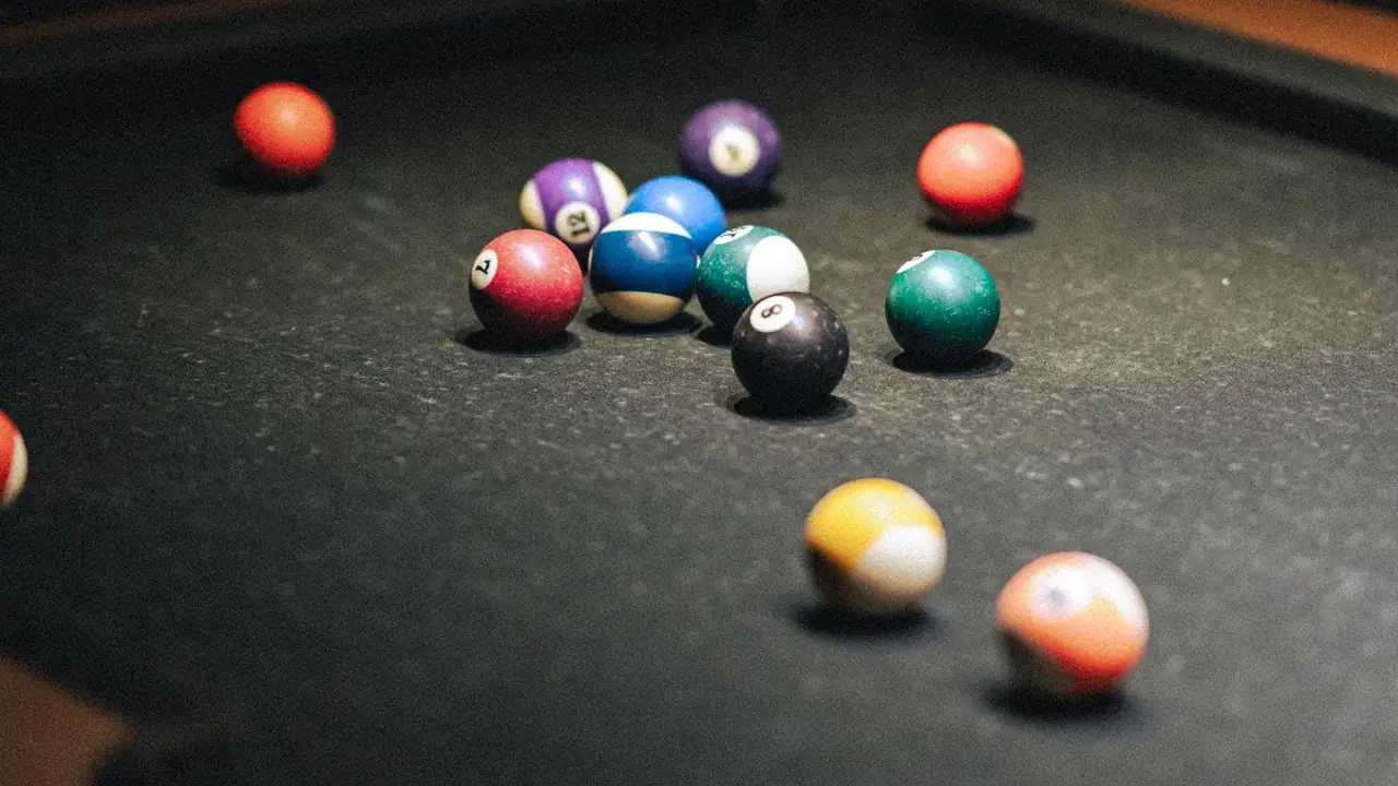 a triangle rack of colorful pool balls on a table, image for pool table jokes about the break