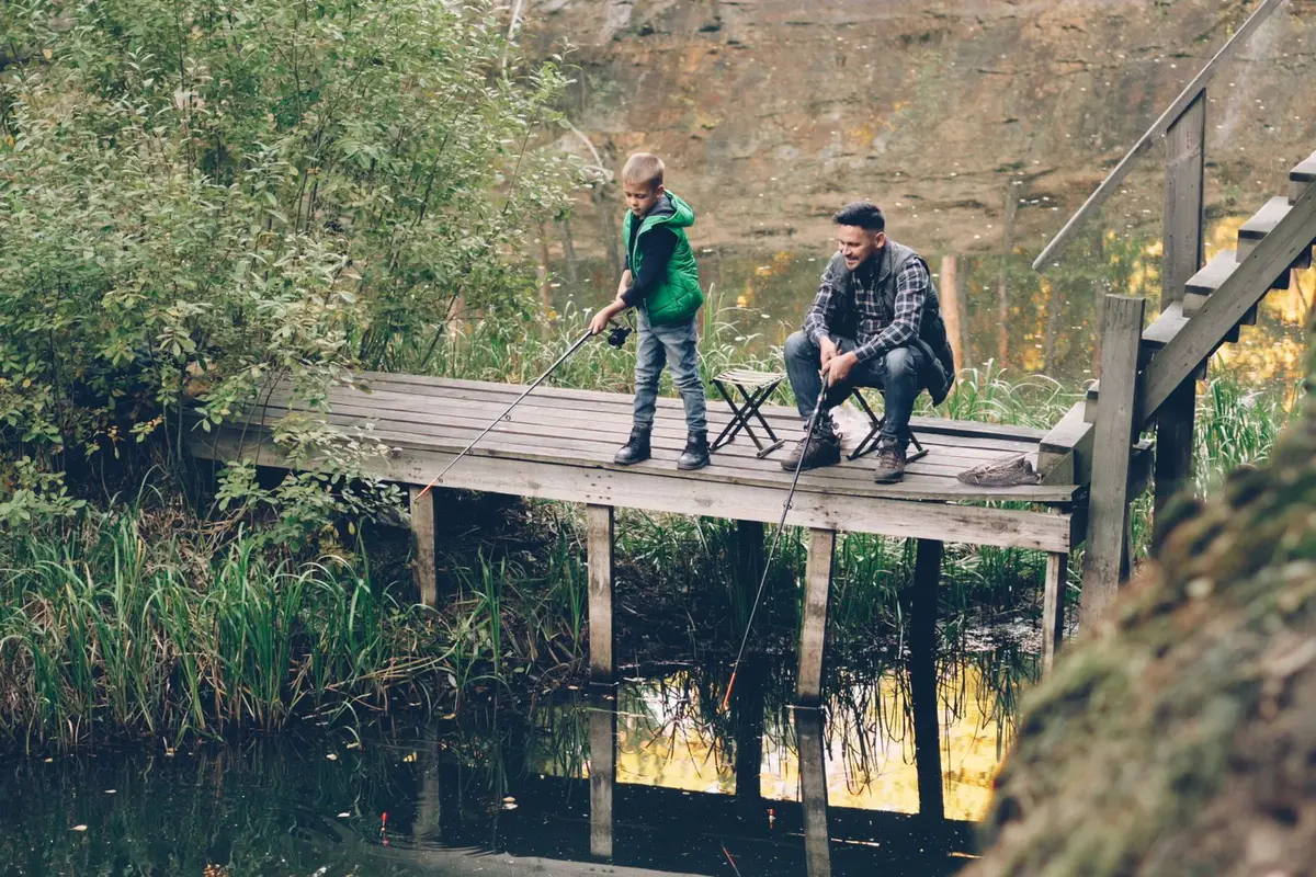 father and son fishing from a wooden dock, dad fish puns and fishing jokes