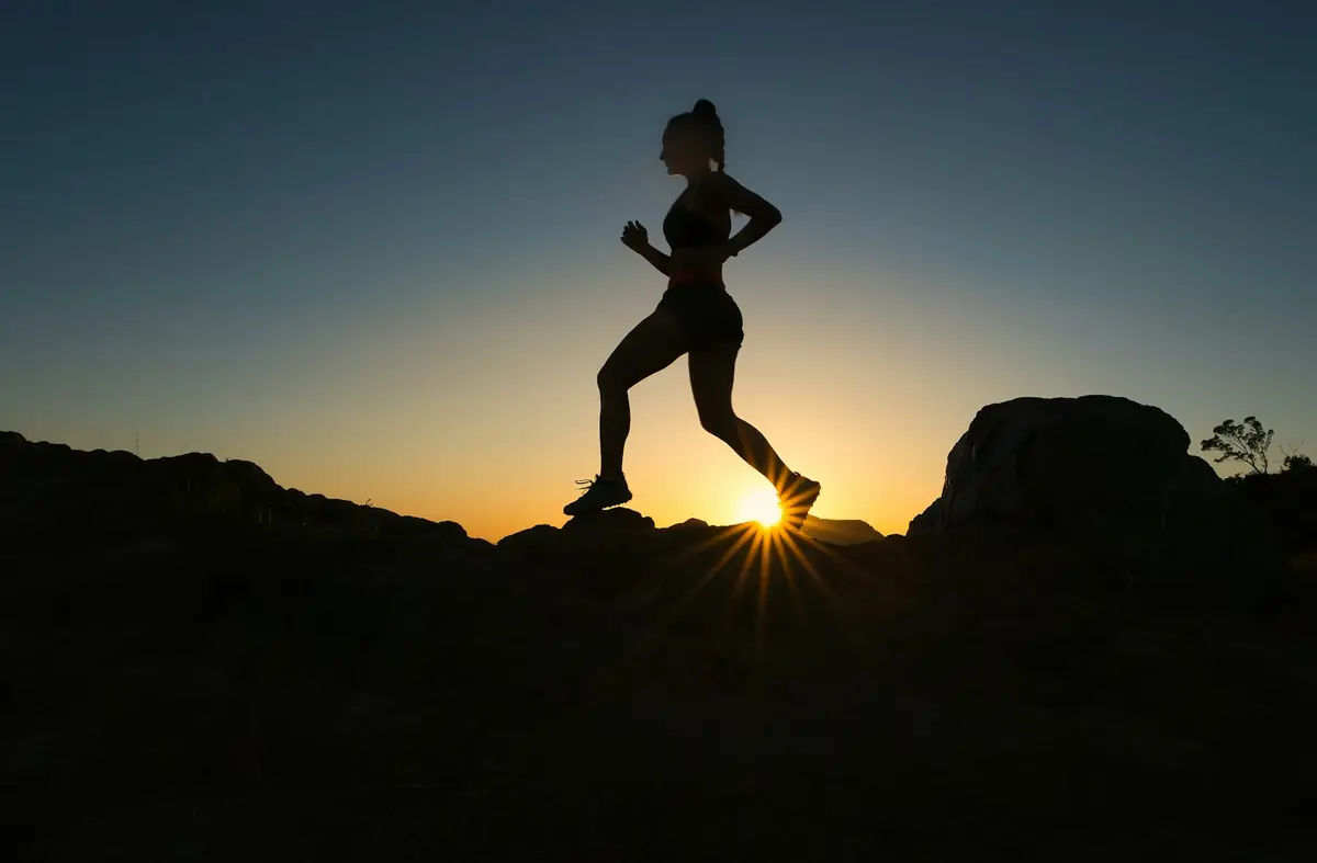 trail runner silhouetted against a low sun on a rocky ridge, scene for trail running puns