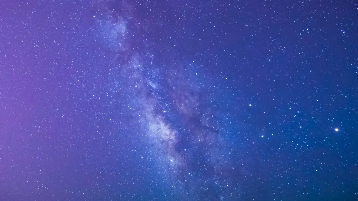 Milky Way and stars across a purple and blue night sky, image for astronomy puns and space jokes
