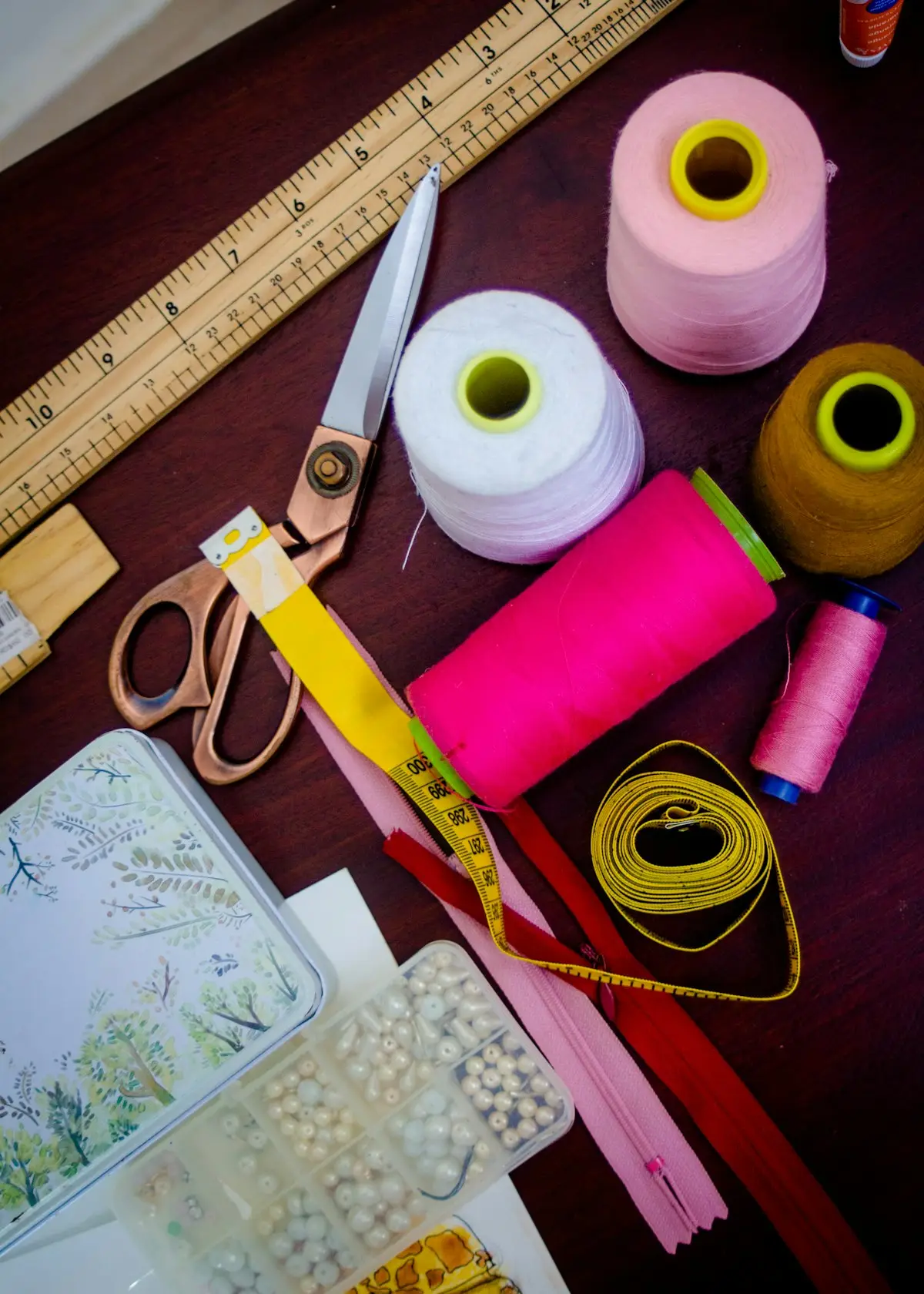 colorful spools of thread arranged beside a pair of scissors, image for thread and fabric puns