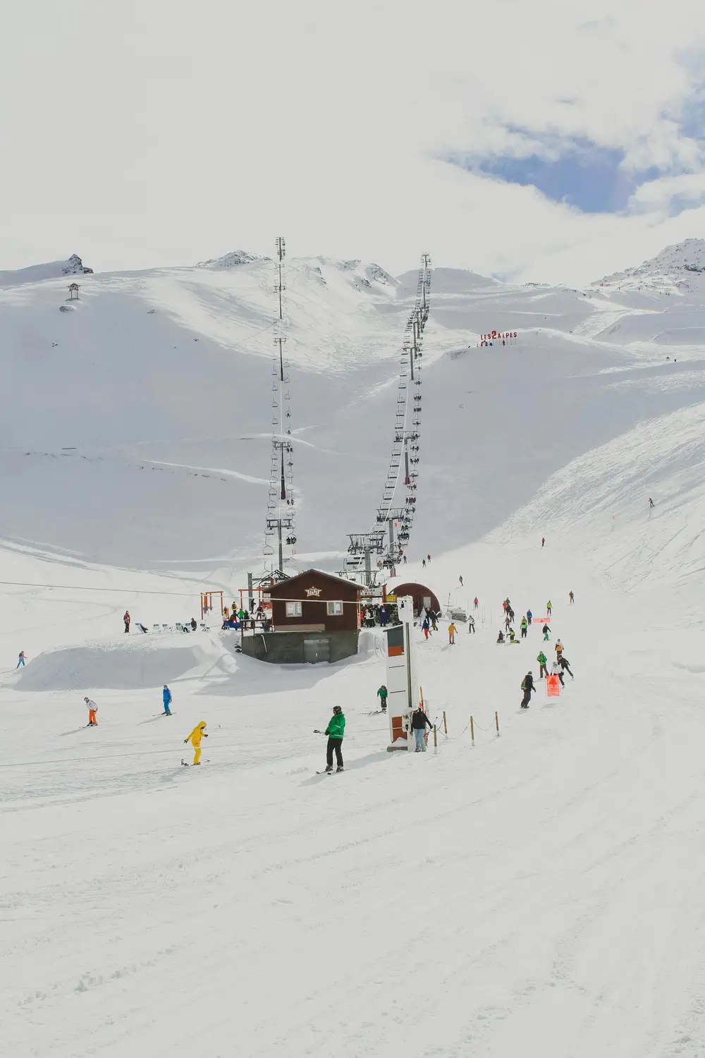 skiers gathered at the base of a chairlift on a bright snowy mountain, scene for skiing puns for instagram