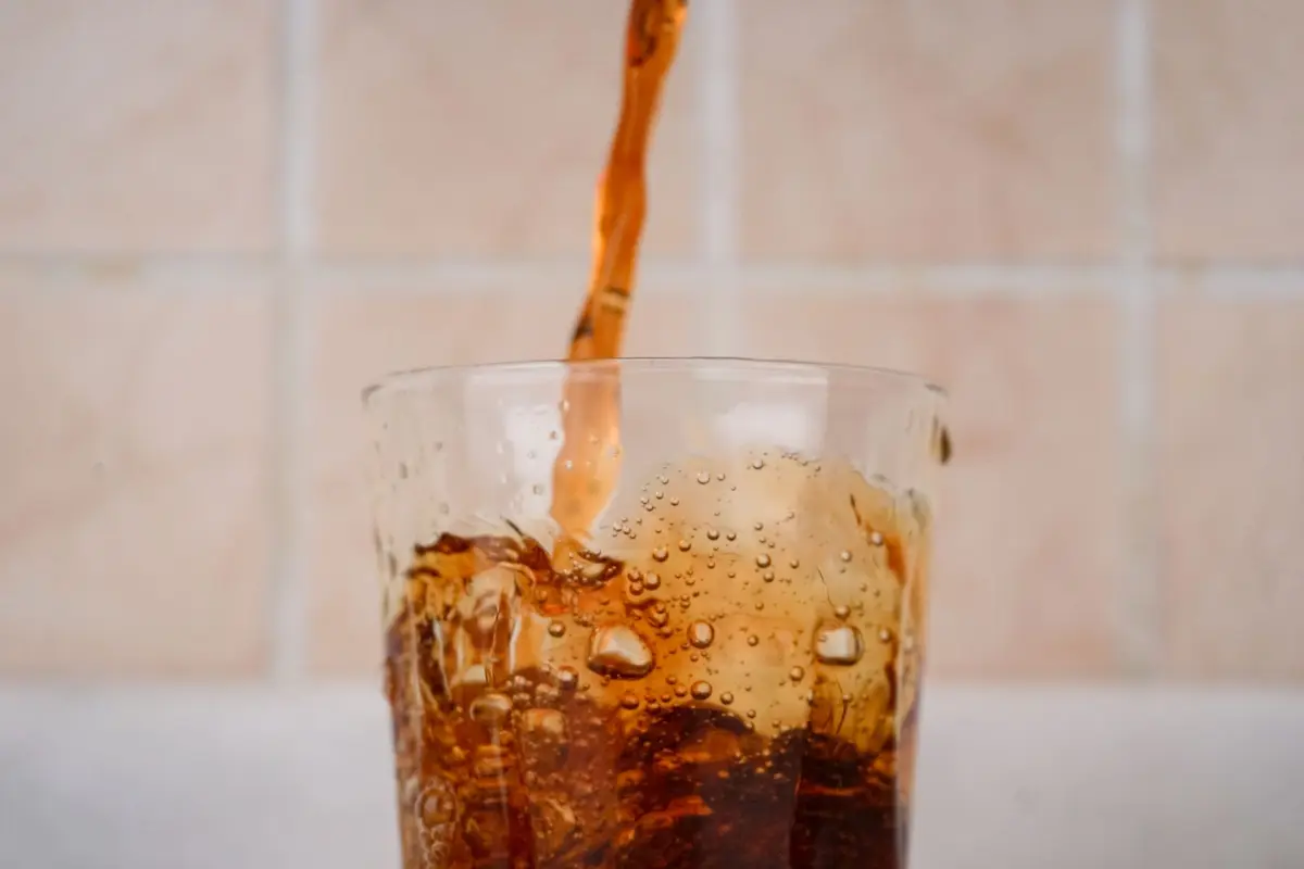 cola splashing into a glass of ice, soda pop puns and fizzy one-liners
