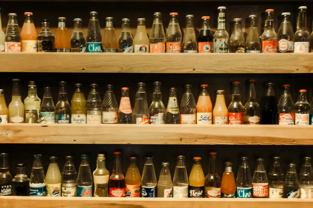 shelves of vintage soda bottles in rows, soda dad jokes for the staff room