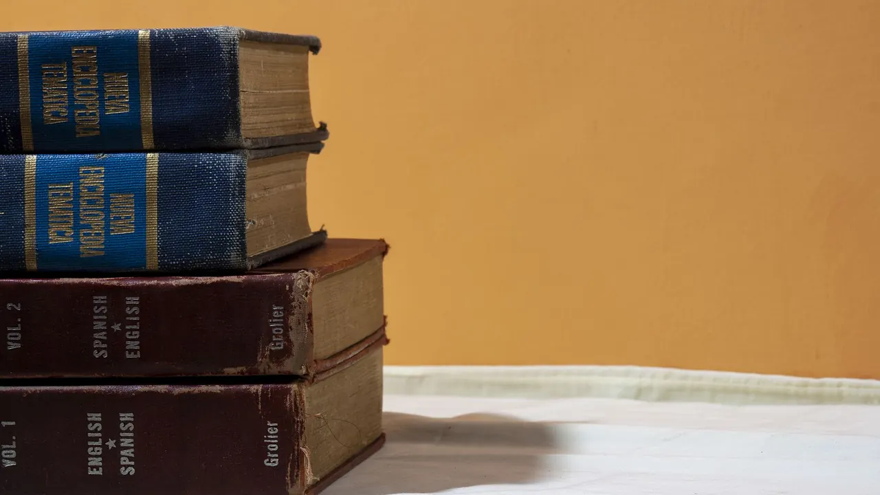 a stack of old dictionaries and books on a shelf, image for spanish teacher jokes