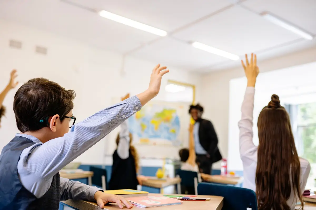 students raising their hands in a classroom, funny jokes for teachers from students