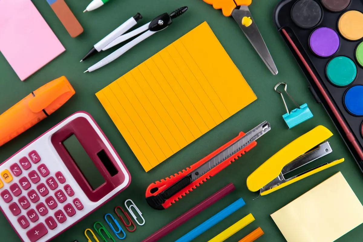 school supplies laid flat on a green surface, image for teacher gift puns and appreciation tags