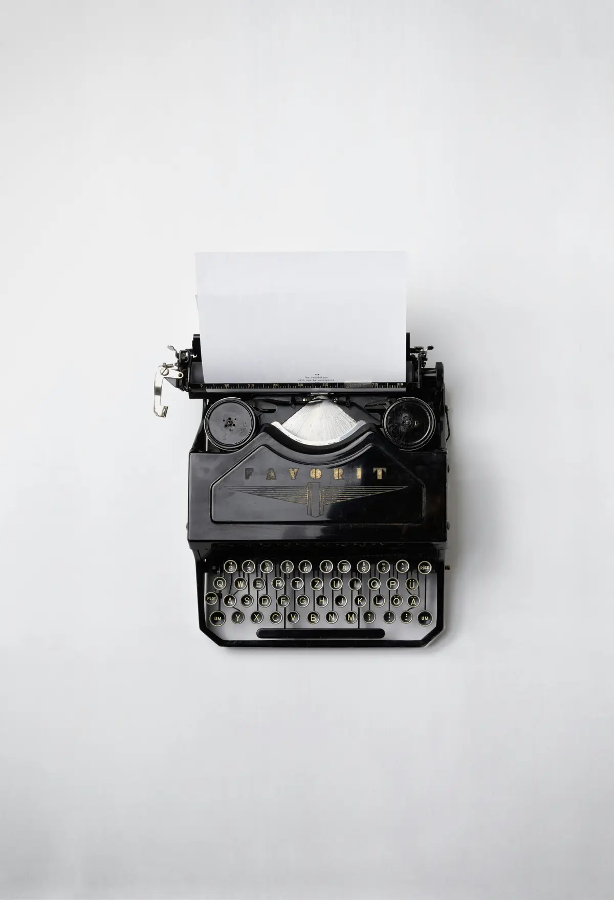 vintage typewriter loaded with blank paper, scene for novelist and author puns