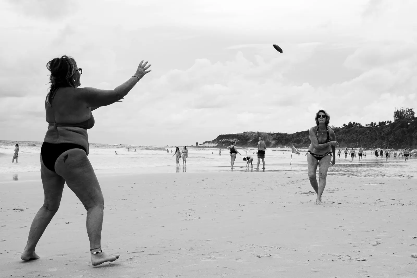 two women playing beach frisbee in Natal Brazil, image for disc golf puns and frisbee jokes