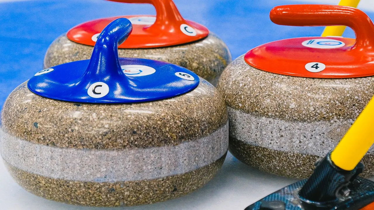 colourful curling stones resting on an indoor ice sheet, image for curling jokes