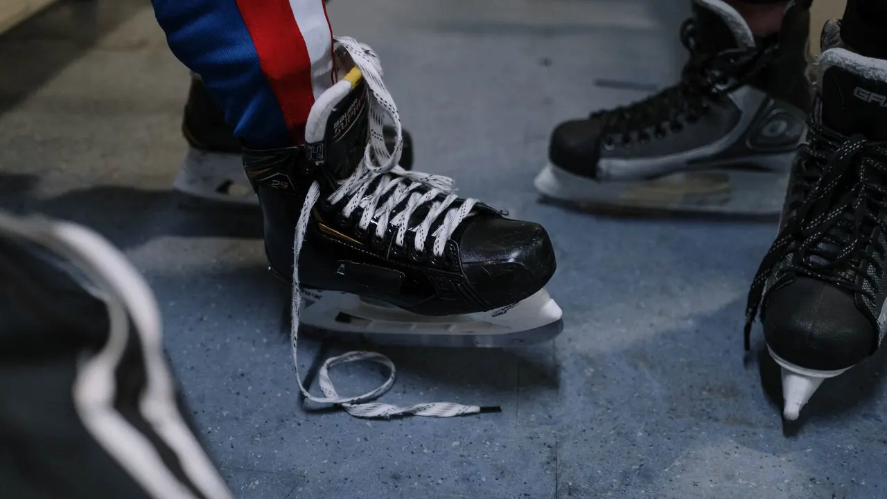 young players lacing up ice hockey skates by the rink, image for ice hockey jokes